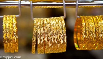 Gold holds gains, but firm dollar weighs