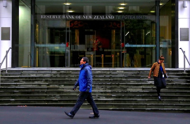 NZ central bank holds rates, tones down hawkish stance